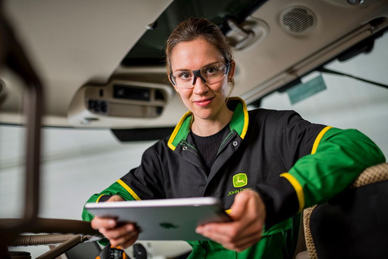 A photograph of a John Deere apprentice using an iPad as part of their training